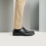 Styled Fit Perspective of Director Wholecut Black Leather Shoes For Men on Model - Natural Daylight Drape